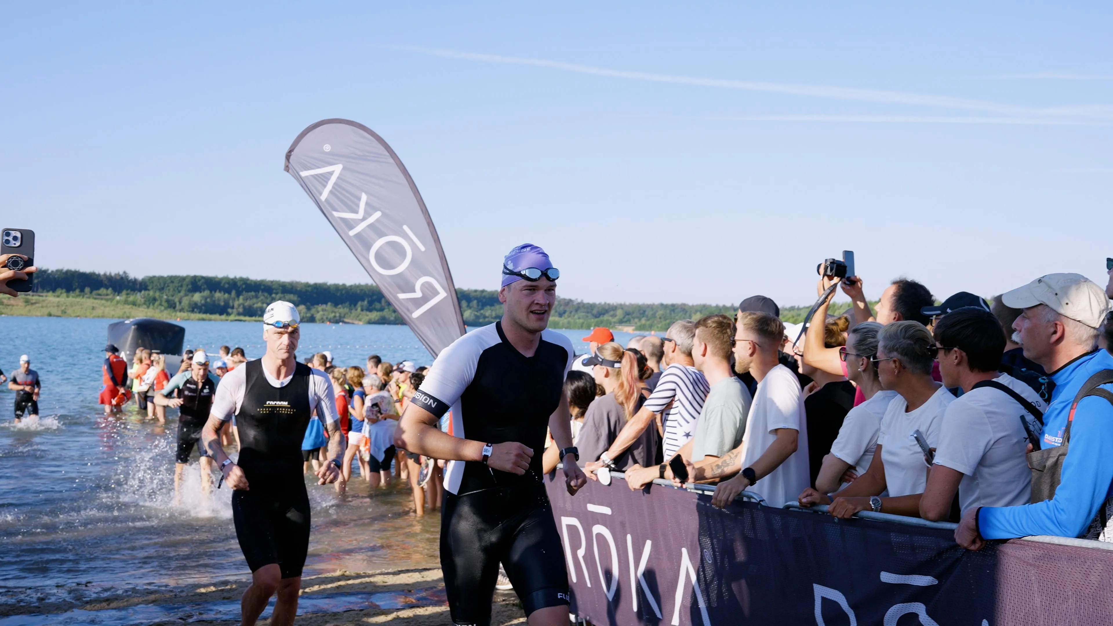 Pascal Kayser läuft beim Ironman aus dem Wasser, am Ufer stehen Zuschauer